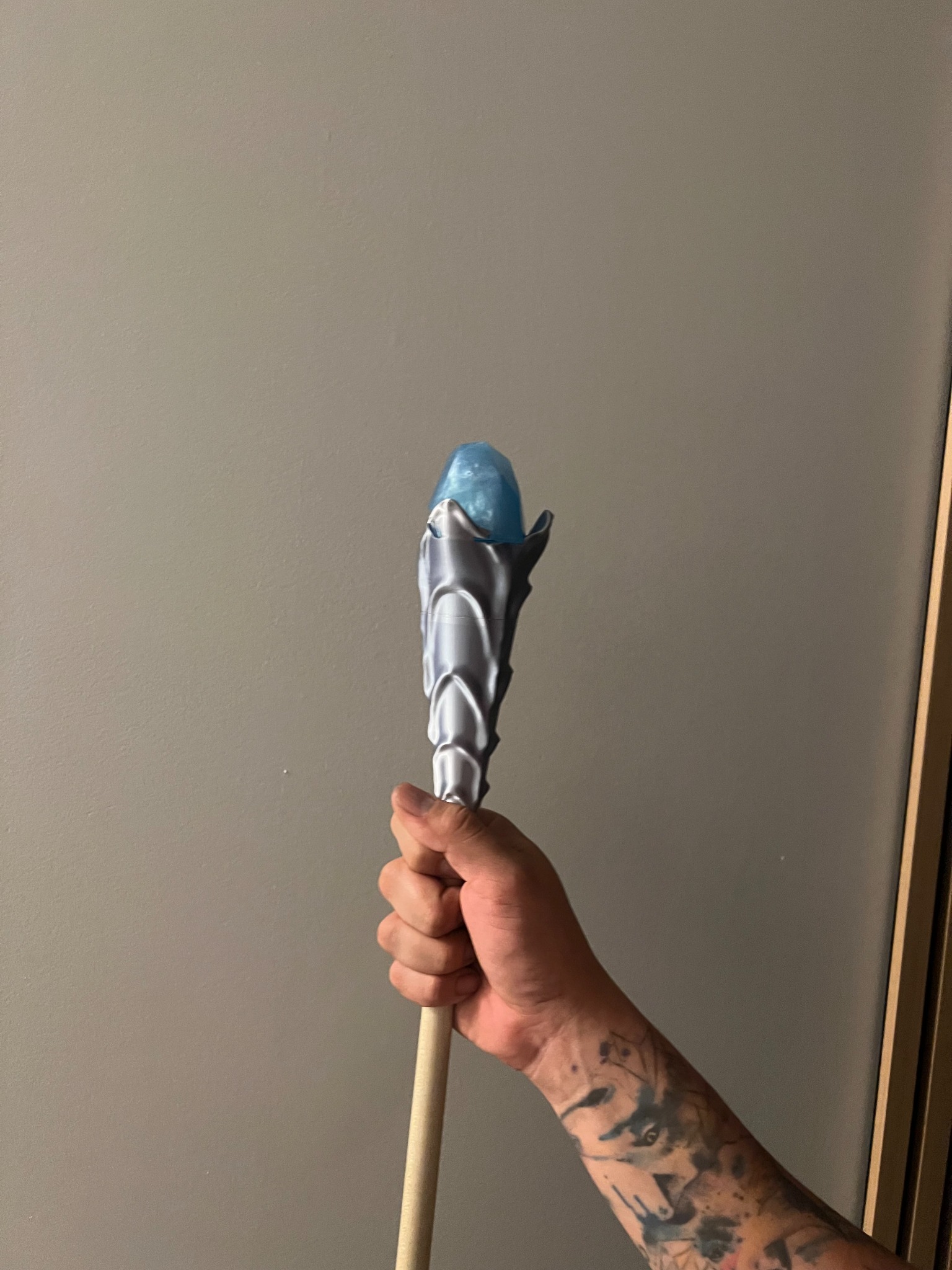 Handheld fantasy staff prop with a sculpted metallic housing and blue crystal